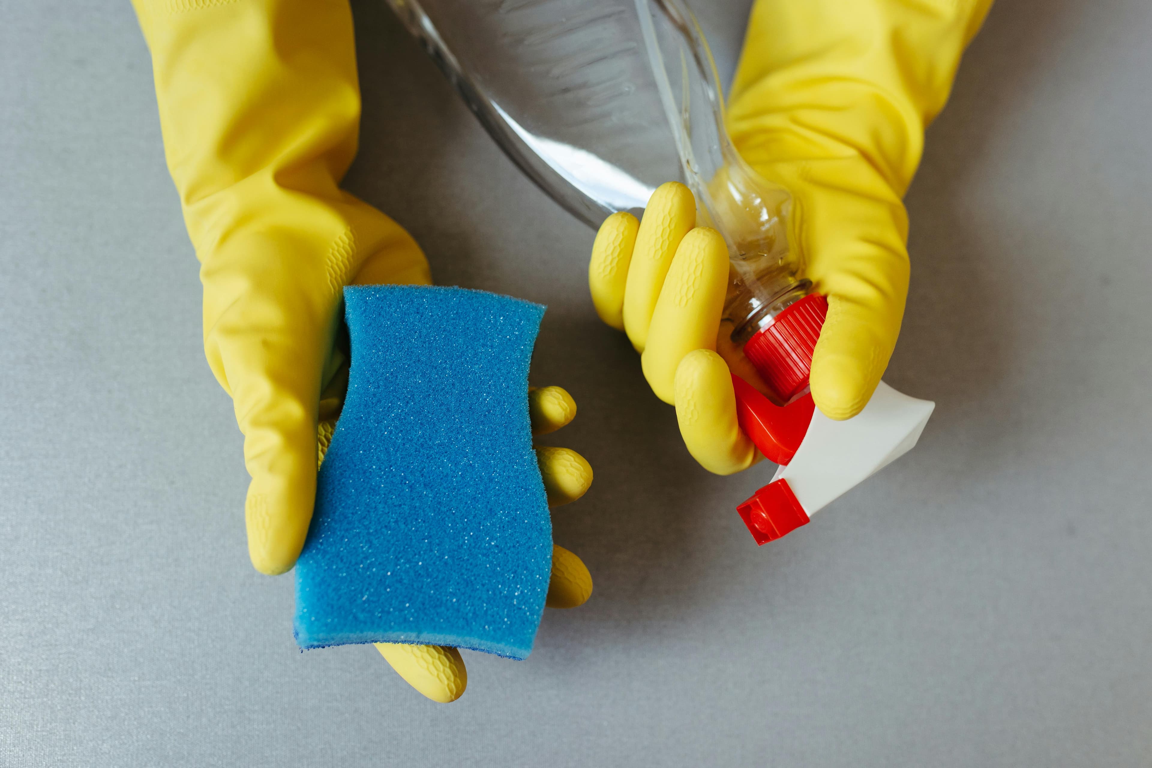 sanitizer yellow glove with blue sponge and cleaning product